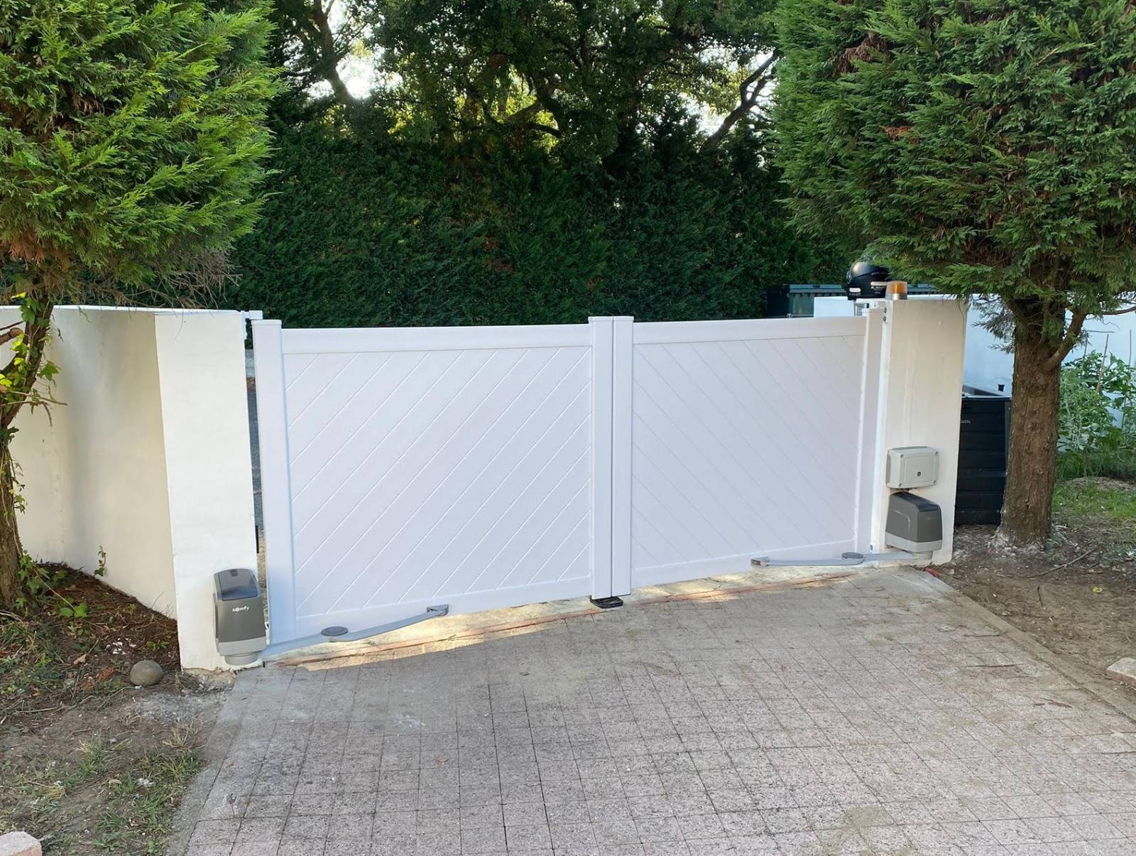 Réalisation extérieur d'un portail en PVC à double battant motorisé en blanc par Daniel Moquet Aix-en-Provence