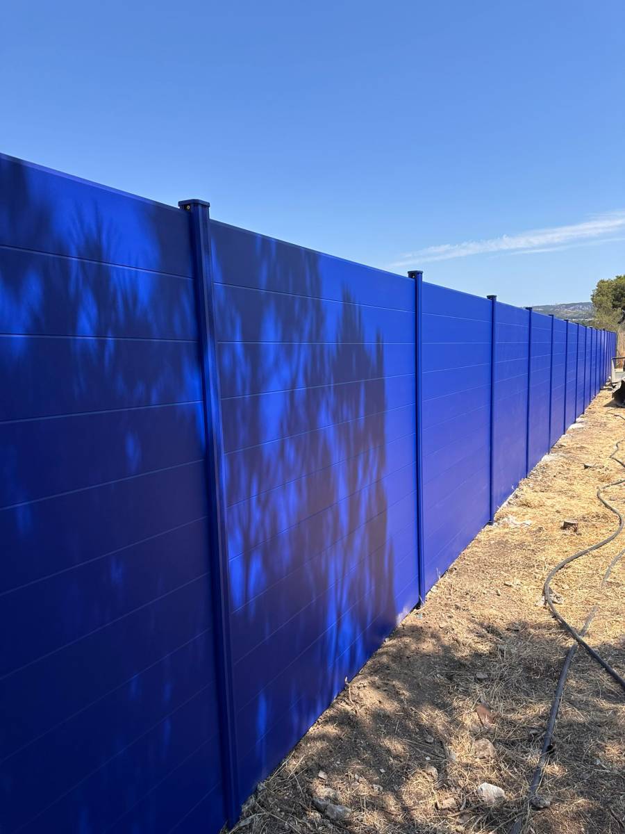 Clôture en aluminium bleue pour un site industriel à Marseille avec lettres découpées et logos intégrés
