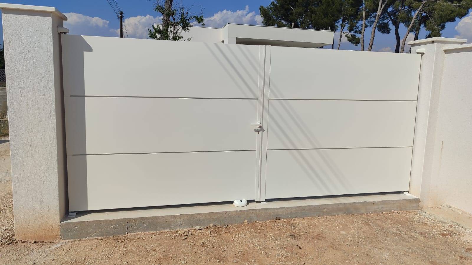 Portail manuel blanc à double battant installé sur une maison traditionnelle à Aix-en-Provence par Théo Créations