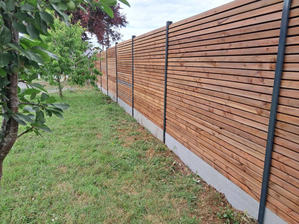 Clôture en bois adaptable aux terrains en pente pour conjuguer esthétisme et fonctionnalité dans votre jardin dans le bassin Aixois.
