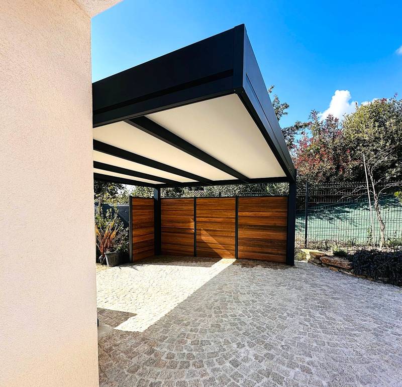 Un carport en aluminium clôturé avec panneaux en composite effet bois à Éguilles pour un abri design et durable