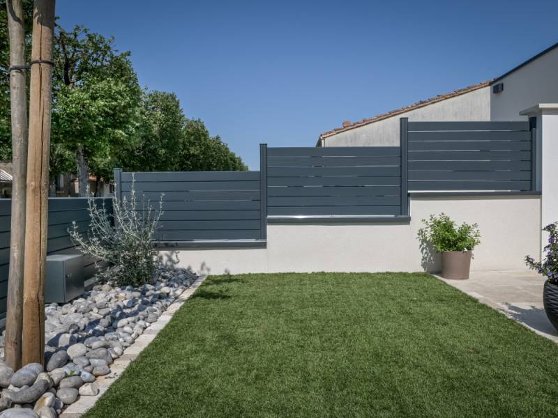 Une clôture aluminium sur mesure pour sécuriser et harmoniser les terrains en pente et jardins modernes à Éguilles