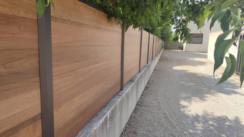 Pose d' une clôture en composite effet bois teck avec lames pleines sur mesure par Daniel Moquet Aix-en-Provence pour allier esthétisme, durabilité et intimité à Ventabren
